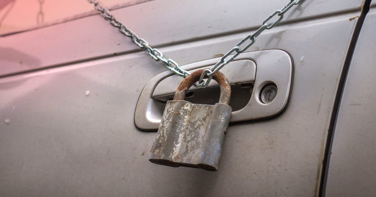 IMPACT Anti-theft Device Door Lock The photo features a car door with a chain and a large rusty lock hanging from the chain.
