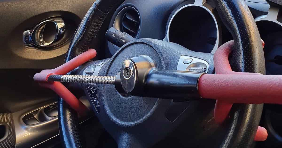 IMPACT News Anti-Theft Device The photo is of an anti-theft device attached to a vehicle steering wheel.